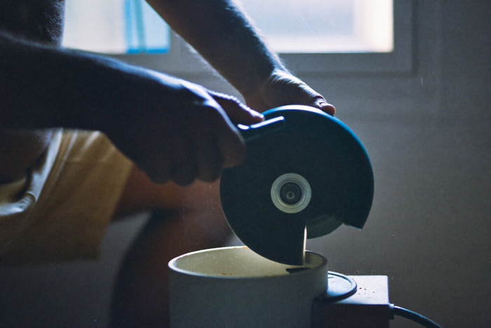 Hands turning the crank of a hand grinder in a cold morning kitchen