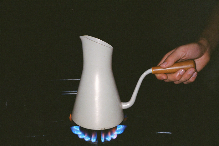 A copper cezve on a gas flame with heat shimmer rising