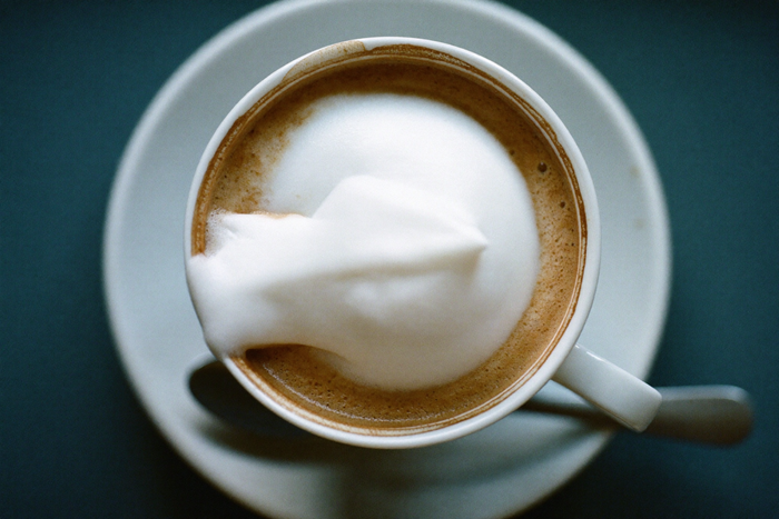 A cappuccino seen from above, foam standing proud of the rim