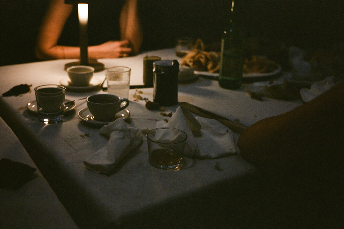 Small coffee cups among used glasses on a table after a long meal