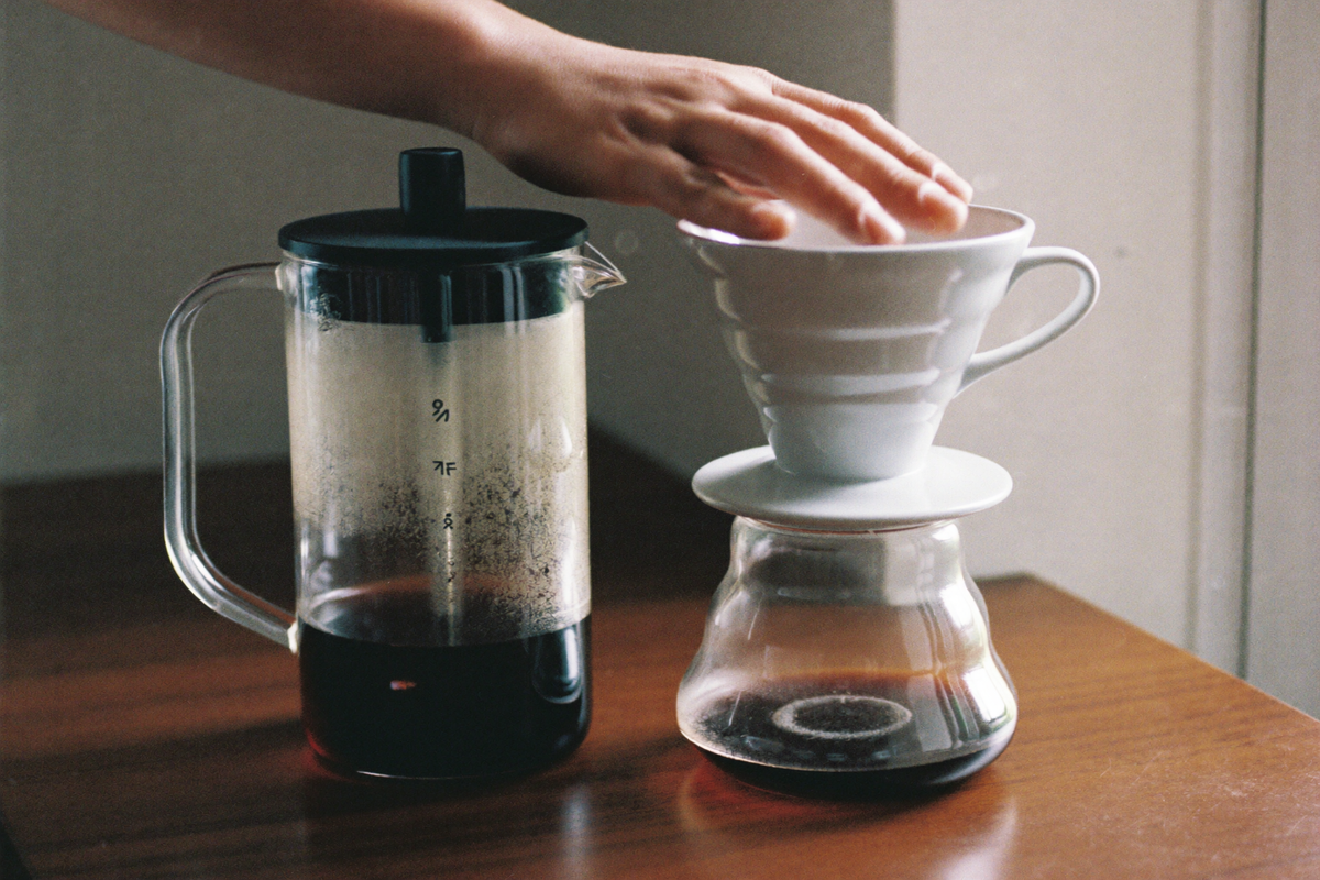 A French press and a cone dripper brewing side by side